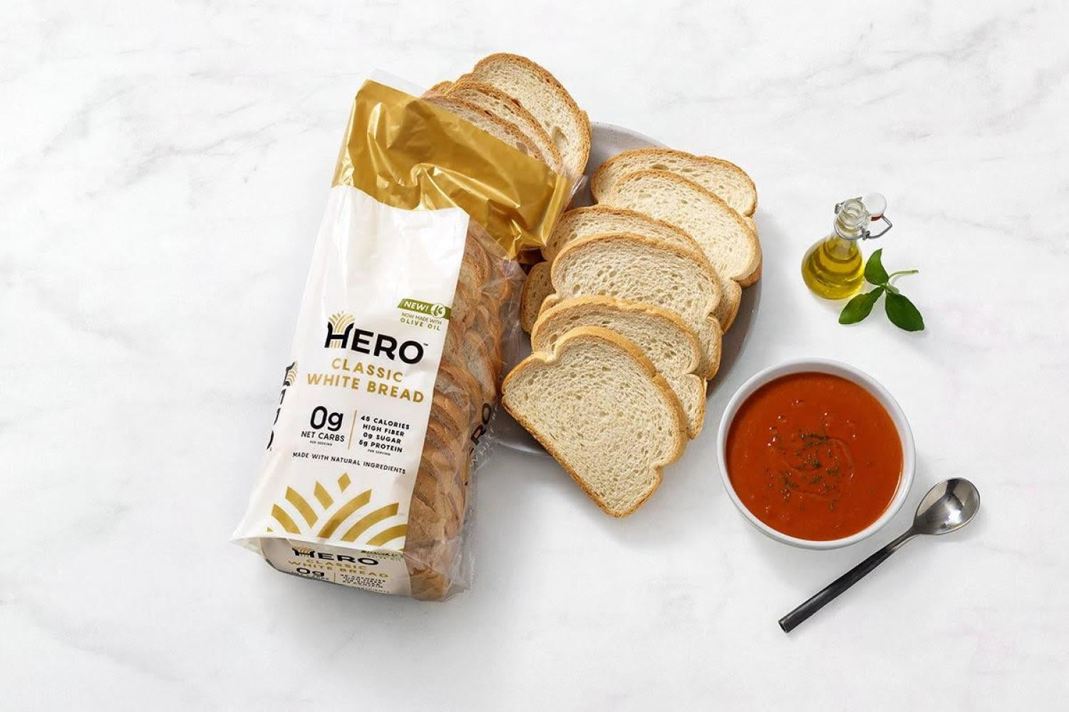 Hero面包在大理石表面上,旁边有橄榄油和红酱。